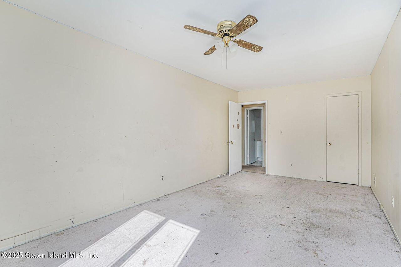 15 Parkview Loop Staten Island, NY 10314 - Photo 22 of 25 an empty room with a hallway and a fan
