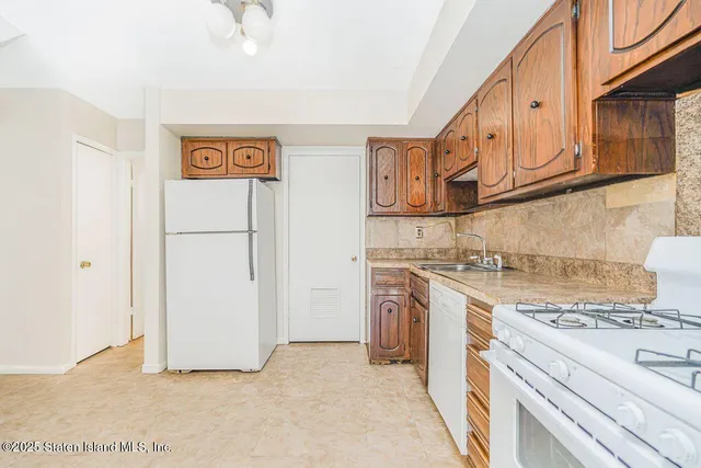 a kitchen with stainless steel appliances granite countertop a refrigerator and a stove
