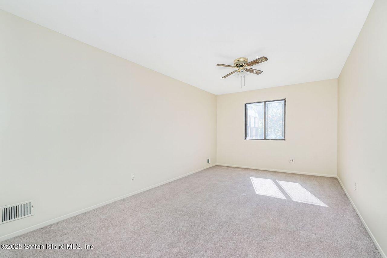 15 Parkview Loop Staten Island, NY 10314 - Photo 6 of 25 an empty room with windows and chandelier fan