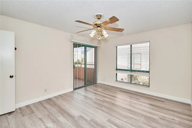 a very nice looking room with wooden floor closet and windows