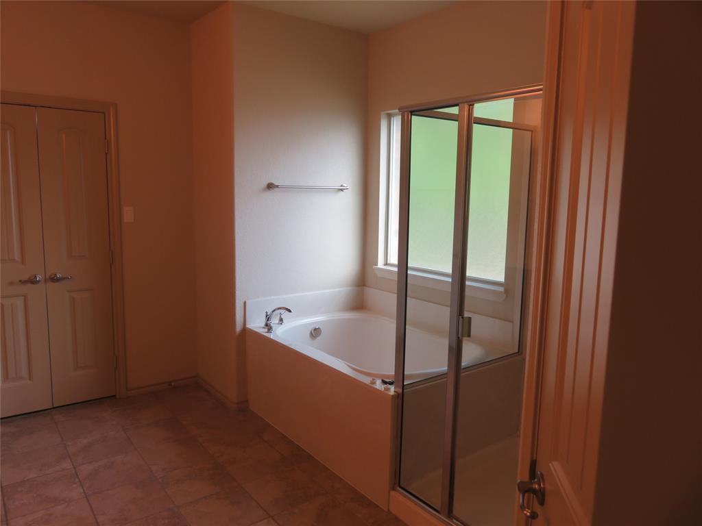 1122 Walter Stephenson Road Midlothian, TX 76065 - Photo 17 of 26 Bathroom featuring a soaking tub with mounted fixtures, a clear glass shower enclosure, and a window with privacy glass