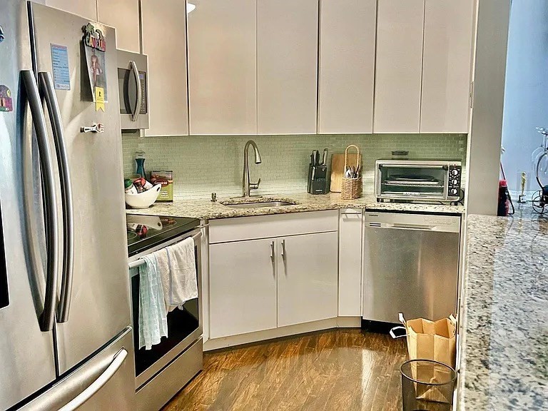 205 Ferry Street, Unit 101 Everett, MA 02149 - Photo 2 of 10 a kitchen with stainless steel appliances granite countertop a refrigerator sink and stove