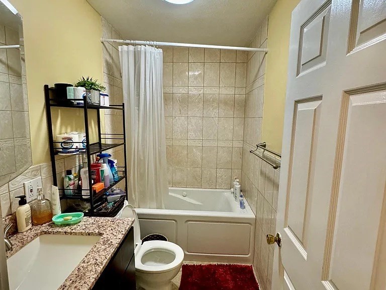 205 Ferry Street, Unit 101 Everett, MA 02149 - Photo 6 of 10 a bathroom with a granite countertop sink toilet and shower