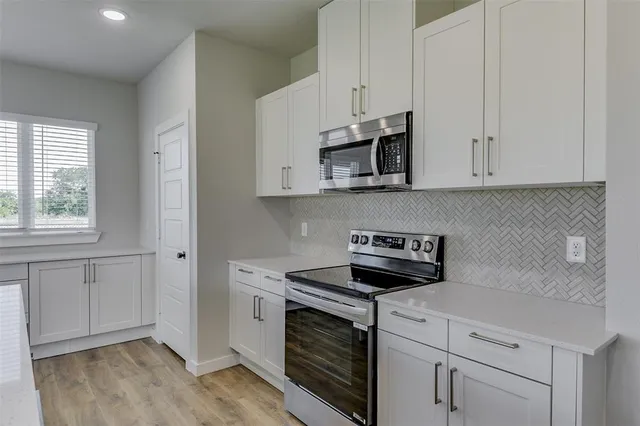 a kitchen with white cabinets stainless steel appliances and sink