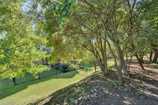 a view of a backyard with floor to ceiling window and wooden fence