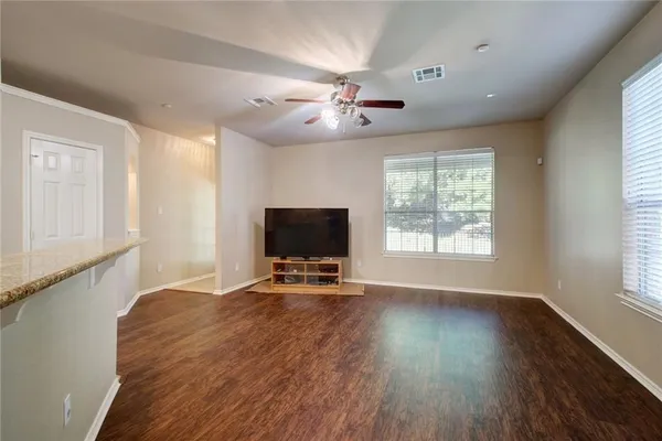 a view of a livingroom with wooden floor and a ceiling fan