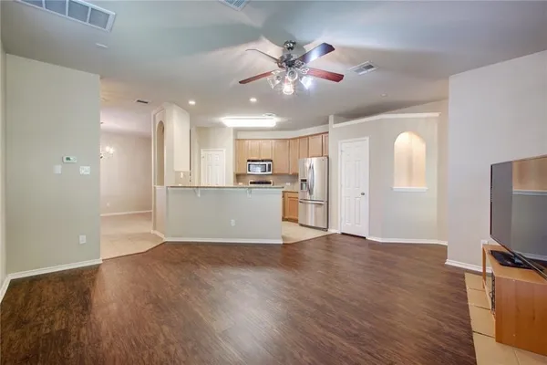 a view of a kitchen with a fridge wooden floor and a kitchen