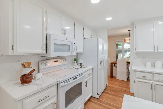 a kitchen with stainless steel appliances white cabinets and a refrigerator