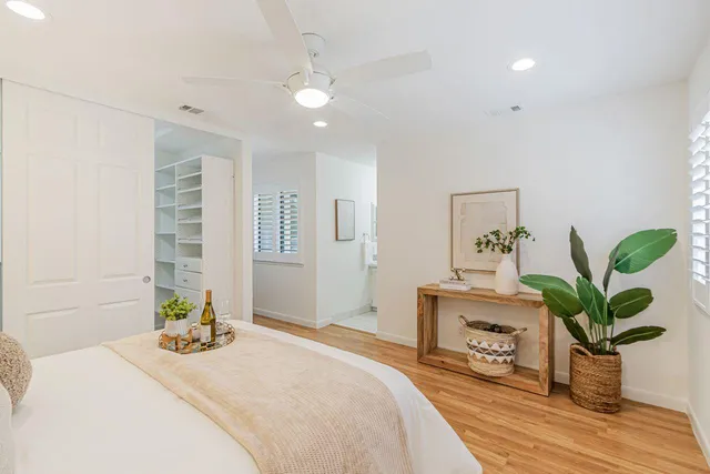 a bedroom with a bed dresser and a potted plant