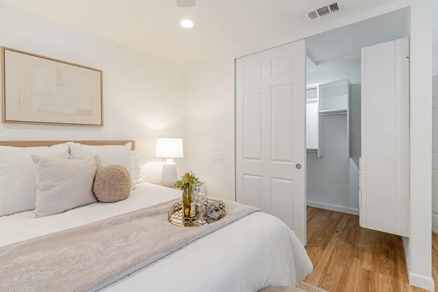 a bedroom with a bed and a painting on the wall