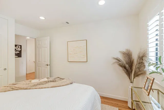 a bedroom with a bed and a potted plant