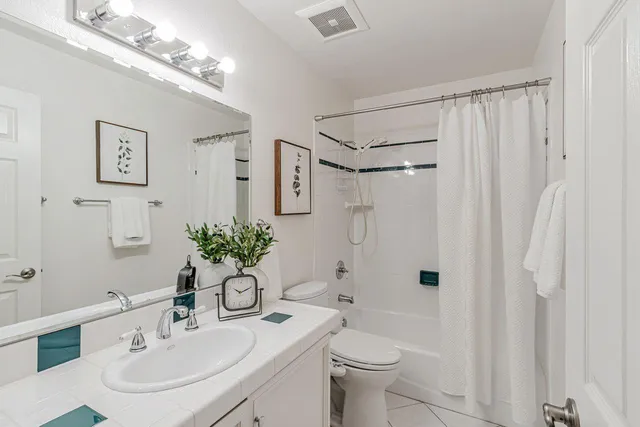 a bathroom with a sink toilet a mirror and shower