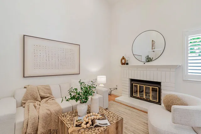 a living room with furniture a fireplace and a large mirror