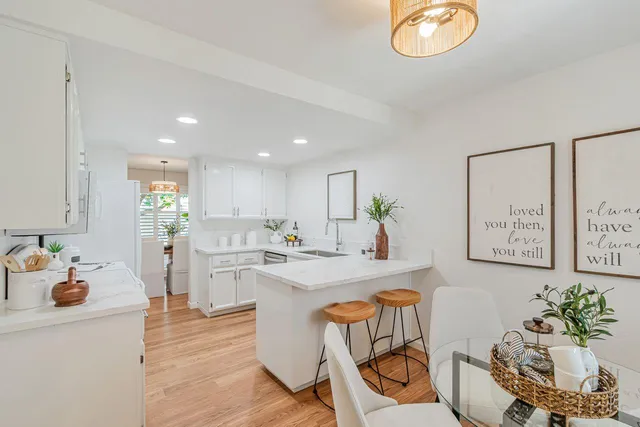 a kitchen with white cabinets and couches