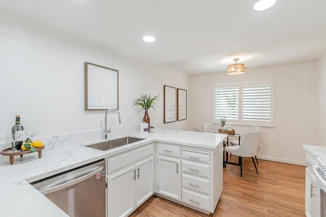 a kitchen with a sink cabinets and wooden floor