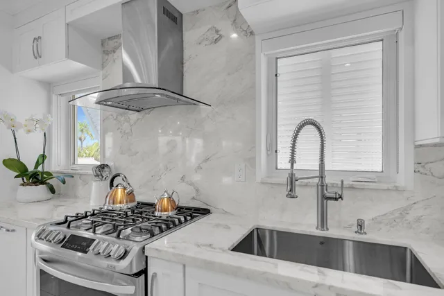 a view of kitchen with kitchen island stainless steel appliances refrigerator stove dining table and chairs