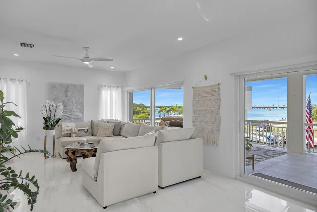 a bedroom with a bed a couch and large windows