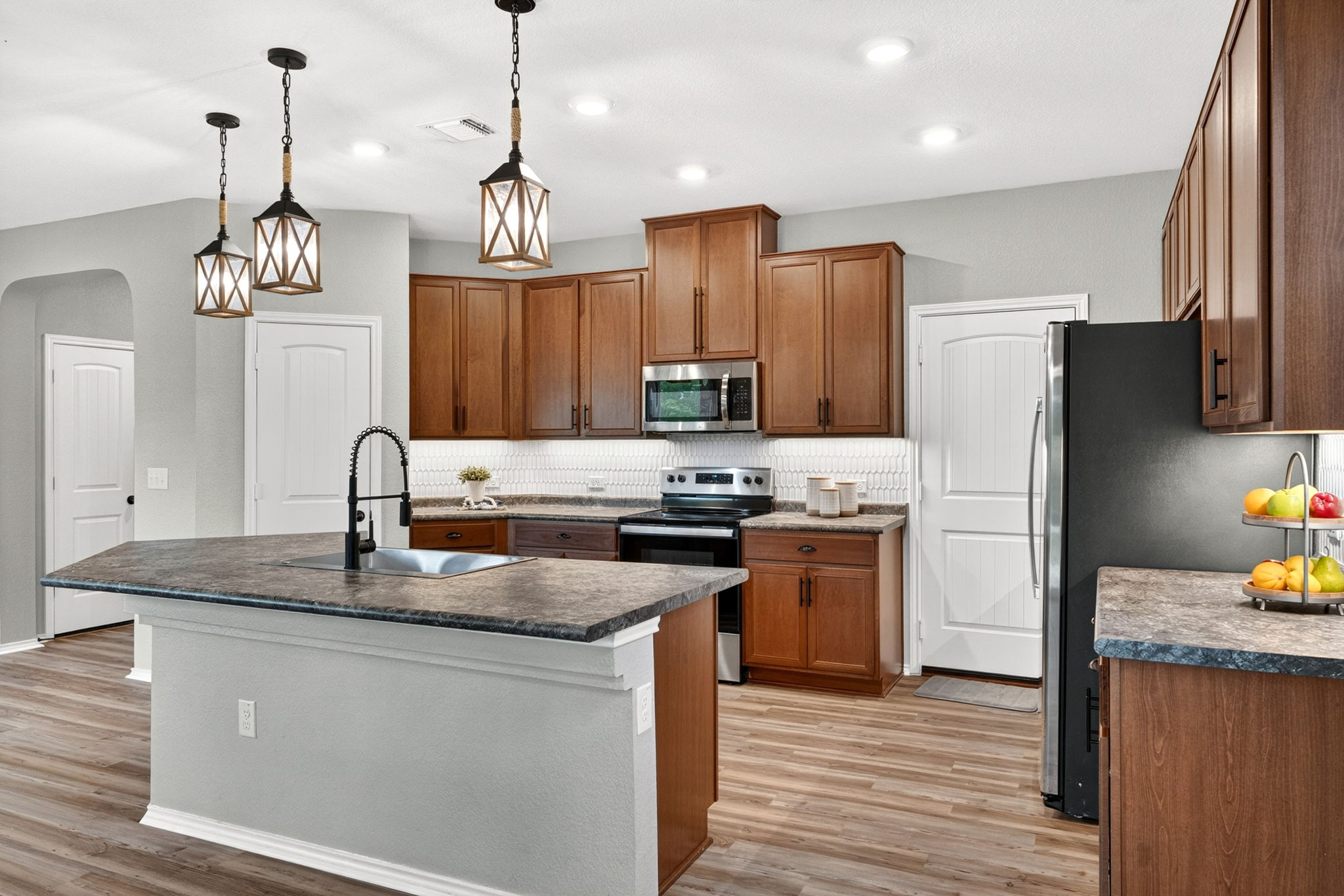 326 Linden Street Bastrop, TX 78602 - Photo 24 of 39 Large kitchen island with a deep single-bowl sink. Beautiful tile backsplash, undercabinet LED lighting & stainless steel appliances.
