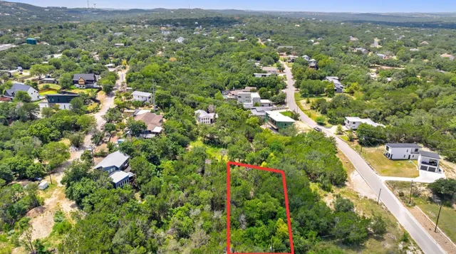 an aerial view of residential houses with outdoor space and trees