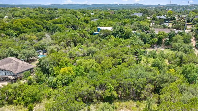 an aerial view of a house with swimming pool and outdoor seating