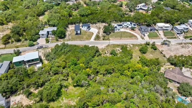 an aerial view of residential houses with outdoor space and trees