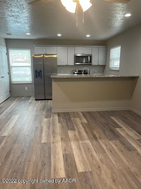 102 8th Street Farwell, TX 79325 - Photo 20 of 21 a kitchen with stainless steel appliances granite countertop a refrigerator and a stove top oven