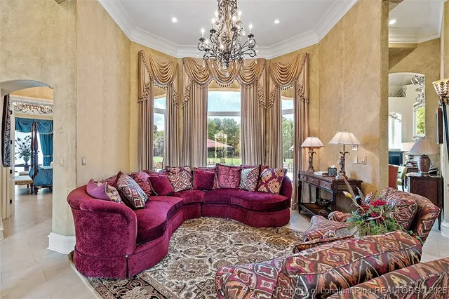 a living room with furniture chandelier and large windows