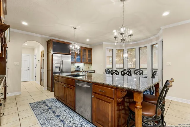 a kitchen with stainless steel appliances kitchen island granite countertop a sink and cabinets