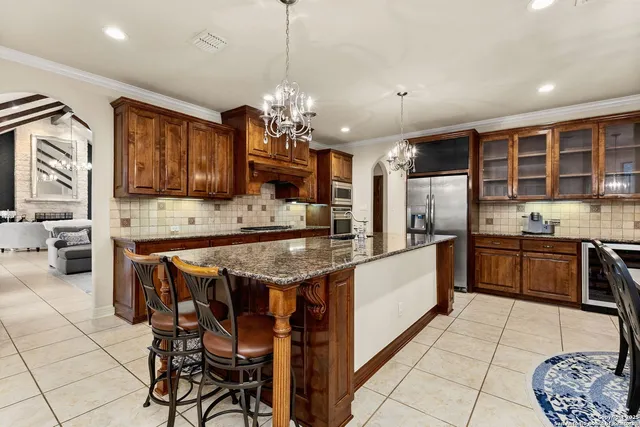a large kitchen with granite countertop a stove a sink a counter space and dining table