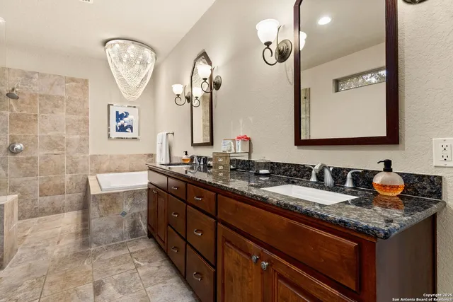 a bathroom with a granite countertop double vanity sink and a mirror