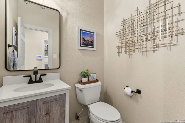 a bathroom with a granite countertop sink mirror and toilet