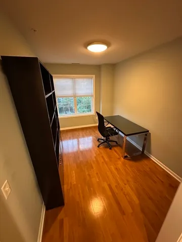 a view of a room with wooden floor and windows