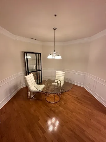a dining room with furniture a chandelier and wooden floor