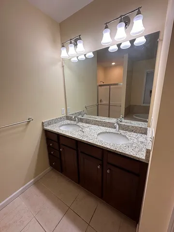 a bathroom with a granite countertop sink and a large mirror
