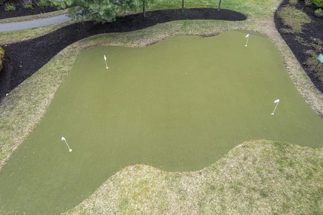 a view of a house with a yard and basketball court