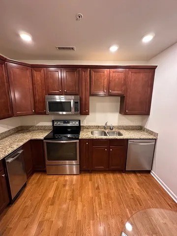 a large kitchen with granite countertop wooden cabinets a stove and a granite counter top