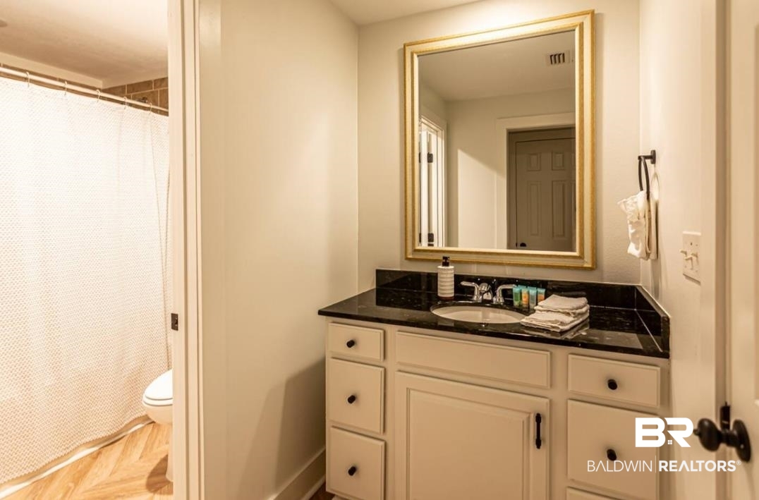 27800 Canal Road, Unit 212 Orange Beach, AL 36561 - Photo 27 of 43 Bathroom with vanity, toilet, baseboards, a shower with shower curtain, and visible vents