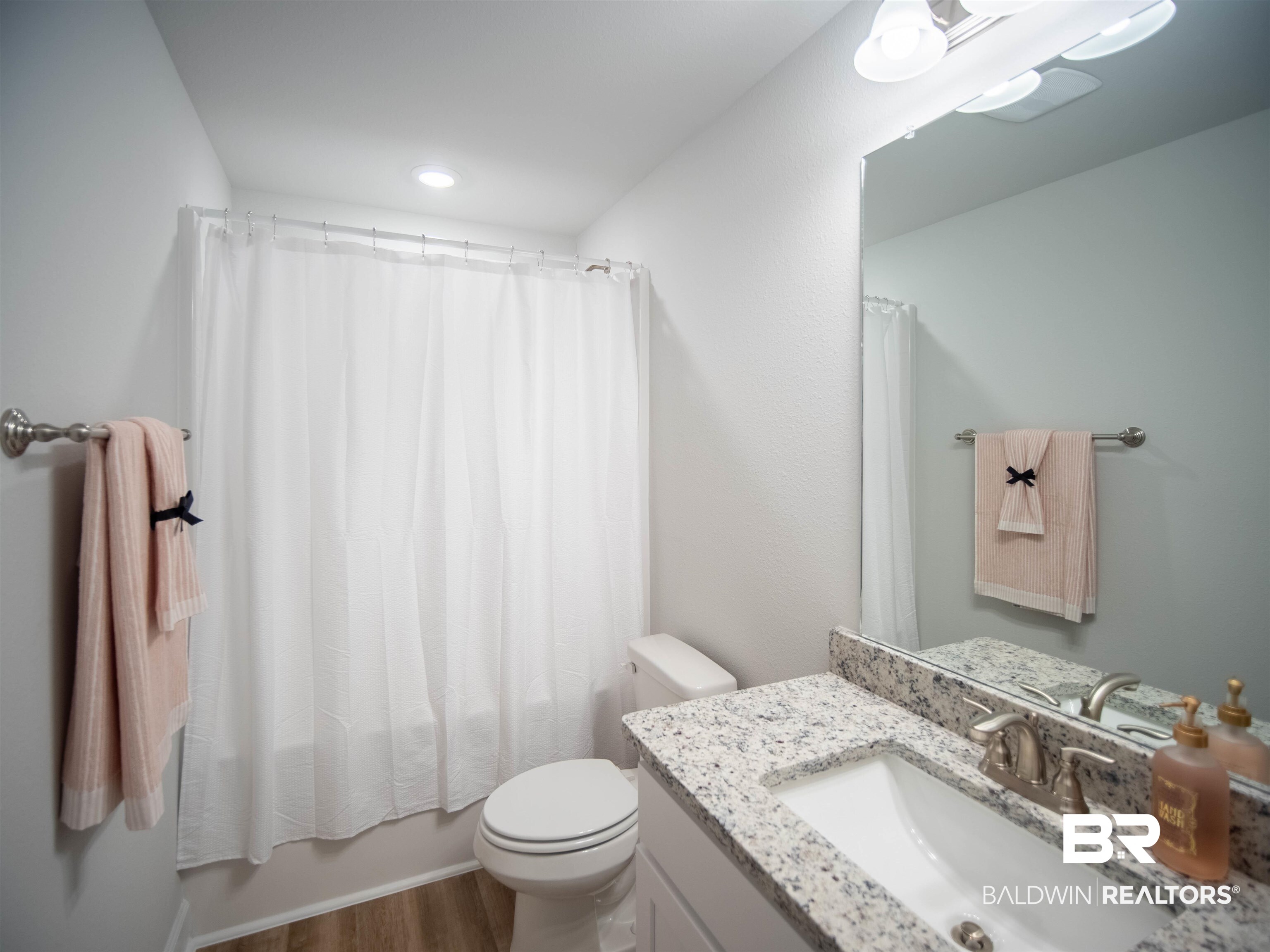 12646 Michigan Avenue Elberta, AL 36530 - Photo 30 of 47 Bathroom featuring vanity, wood finished floors, and shower / bath combination with curtain