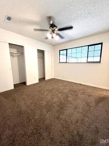 en empty room with windows and ceiling fan