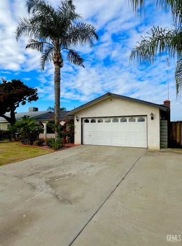 a front view of a house with palm trees