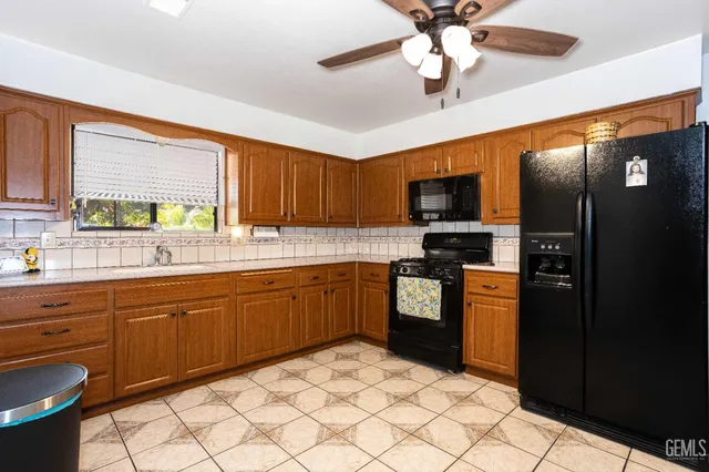 a kitchen with stainless steel appliances granite countertop a refrigerator a sink dishwasher a stove top oven a washer and dryer with wooden floor