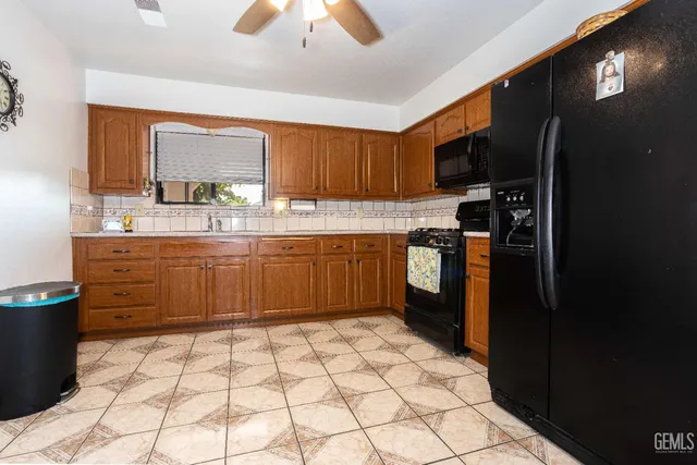 a kitchen with a sink a stove cabinets and a window