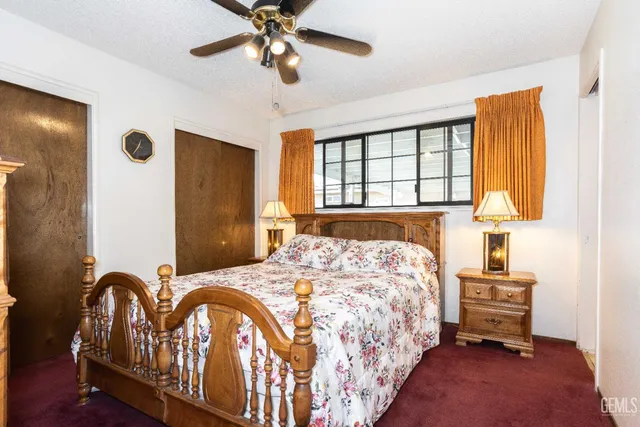 a bedroom with a bed next to a window and a chandelier