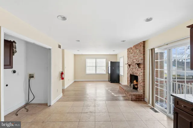 a view of an empty room with closet and a window