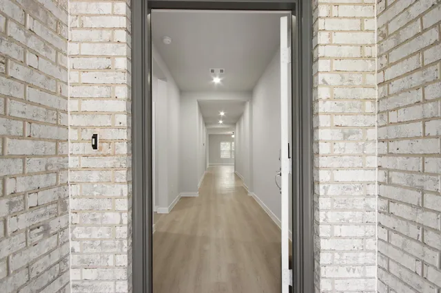 a view of a hallway with brick walls