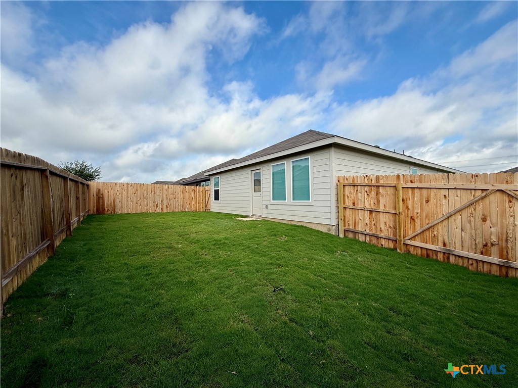 311 Moscato Road New Braunfels, TX 78130 - Photo 34 of 38 a backyard of a house with lots of green space and wooden fence