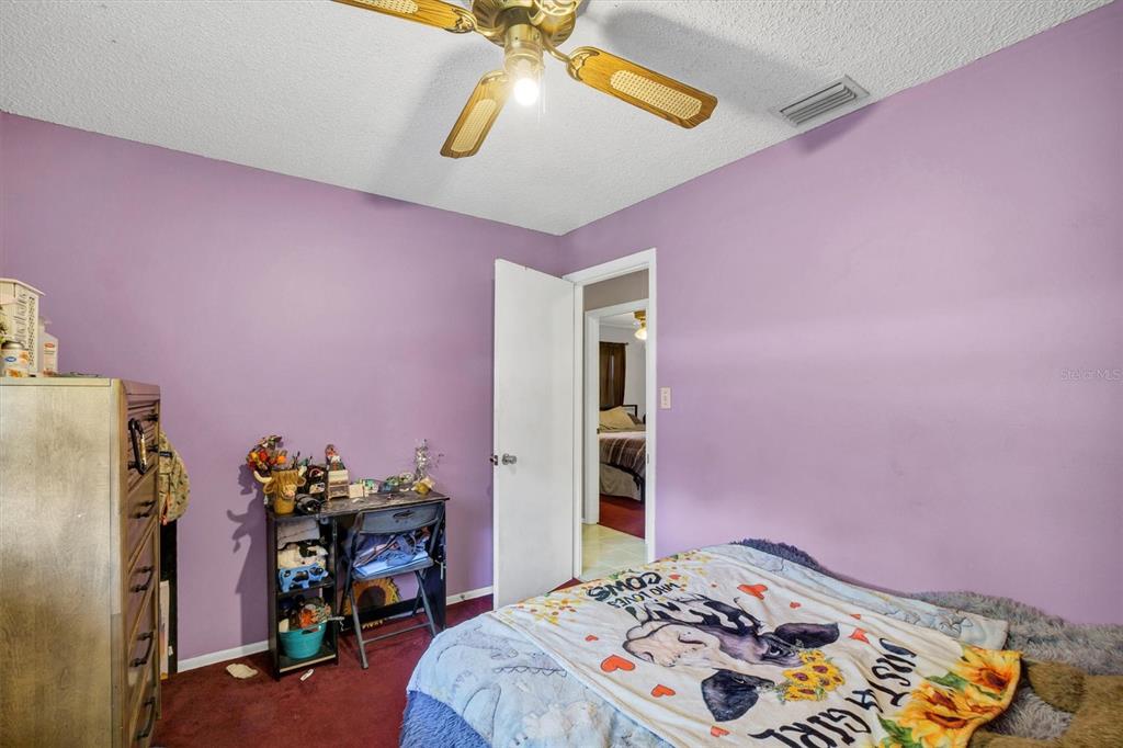 517 Marianna Road Auburndale, FL 33823 - Photo 24 of 37 a bedroom with a bed and a chandelier