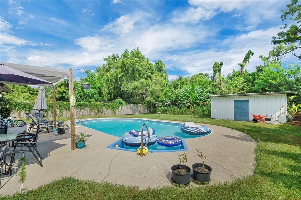 517 Marianna Road Auburndale, FL 33823 - Photo 35 of 37 a view of a backyard with table and chairs potted plants and a large tree