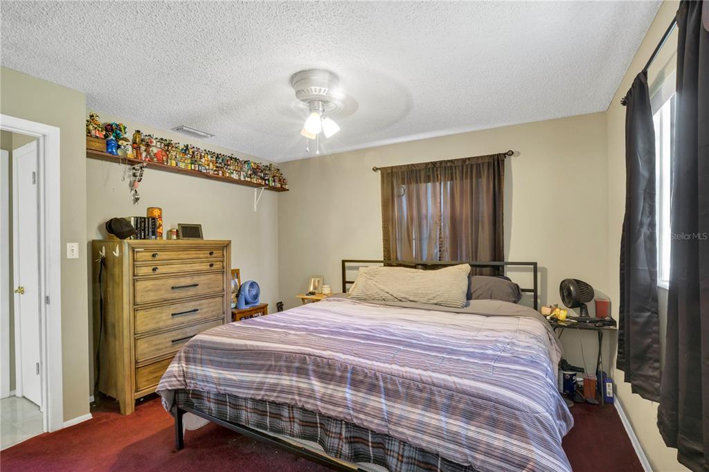 517 Marianna Road Auburndale, FL 33823 - Photo 8 of 37 a bedroom with a bed and a chandelier