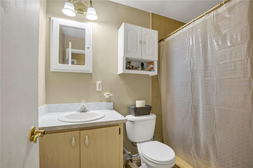 517 Marianna Road Auburndale, FL 33823 - Photo 9 of 37 a bathroom with a sink a toilet and shower curtain
